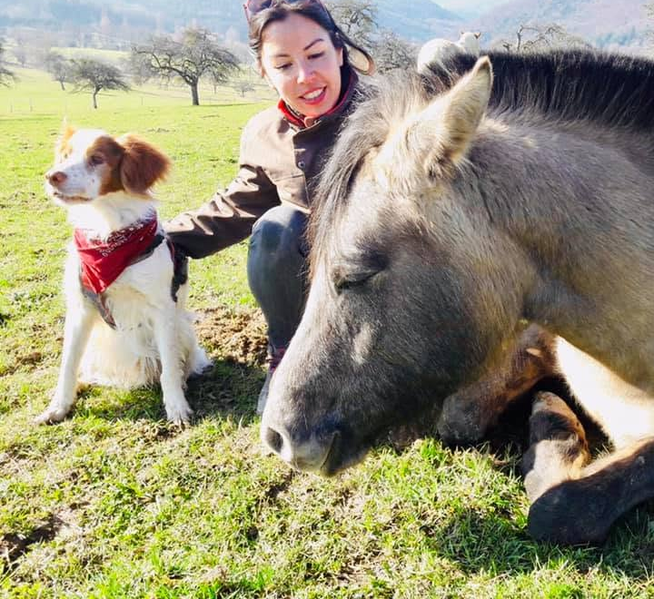 Oriane avec son chien et son cheval couché dans un pré